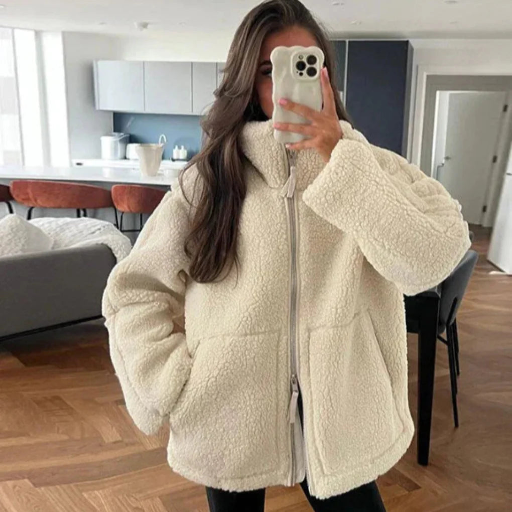 Spiegelaufnahme einer frau, die eine beige lammwolljacke trägt